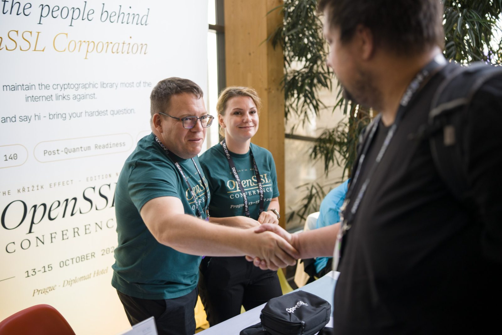 OpenSSL Corporation booth staff shaking hands with an attendee at the stand